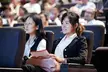 Asian girls in white shirts and black blazers sitting in an auditorium audience at the Asiafruit Congress 2011