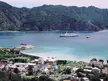Port of Futami in Chichi-jima with a large white cruise ship and boats in a harbor against green mountains