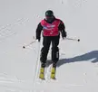 Wu Meng in athletic wear and a pink bib on a snowy mountain slope