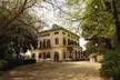 Tempo Reale at the historical Strozzi family villa, a large yellow building with cars on a gravel driveway