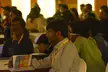 DroidCon India 2013 attendees in hoodies and casual streetwear sitting in a room with lanyards and booklets