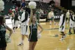 Cheerleaders and basketball players in green and white athletic wear on a wooden court at PSU Stott Center