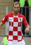 Strinić in a red and white checkered Croatia soccer jersey and white shorts on a sports field
