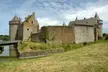 Château de Suscinio stone castle with towers, a moat, and a bridge in a grassy field.