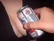 Close-up of a hand holding a Pabst Brewing Co beer can against a person's chest in a black shirt.