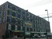 Fairway market storefront in a vintage brick warehouse building in Red Hook, Brooklyn, with cars and people