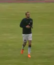 Jeffrey Rentmeister in athletic wear and orange shoes on a green soccer field