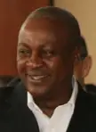 John Dramani Mahama smiling in a white shirt and dark blazer