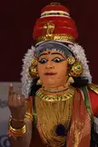 Nangiar koothu performer in red and gold traditional Indian dance costume and headdress