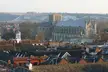 Winchester townscape with red-tiled roofs and a large stone cathedral against distant hills