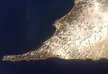 Aerial view of Mashkovtsev and Cape Lopatka, showing snow-covered land meeting dark blue ocean water.