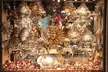 Ornate Venetian masks in a shop window, featuring various colors and vintage costume designs.