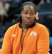 Stricklen wearing an orange Connecticut Sun jacket with black braided hair in an indoor arena.