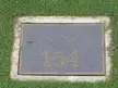 Close-up of plaque 154 at Arcadia Bluffs Golf Club in Arcadia, Michigan, set in a concrete border on green grass.
