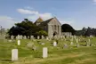 Church of St Mary, a Grade I listed building in Hampshire with a stone church and ruins in a grassy graveyard