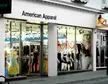 American Apparel storefront on a city street with mannequins wearing a yellow dress and black swimwear