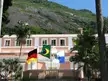 Deutsche Schule Rio de Janeiro pink building with German, Brazilian, and Rio de Janeiro state flags before a mountain