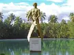 Monument of Roberto Cofresí, a muscular statue with a sword on a pedestal in Boquerón Bay's tropical waters.