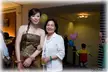 Two beautiful Chinese women with pale skin, one in a strapless olive green satin dress and one in a white shirt