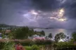 St Lucia coastal resort with pink-roofed buildings, tropical gardens, and a calm bay under a cloudy sky