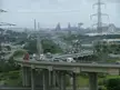 Highway overpass with traffic leading toward industrial factories and electricity pylons in Briton Ferry, Port Talbot
