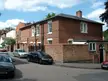 The Park Estate in Nottingham featuring a red brick building and black BMW cars on an urban street