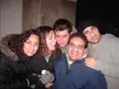 Five friends with white substance on their noses posing against a stone wall at night