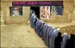 A lineup of people in grey robes waiting to enter a shop cinema in Afghanistan
