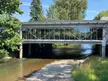 Modern glass building architecture spanning a river with a rocky bank in Renton, Washington