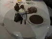 Chocolate cake, chocolate sauce, and ice cream on a white plate, close-up and oddly satisfying