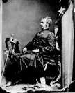 Major General Joseph Hooker in a dark military uniform sitting by a flag in a black and white vintage photo