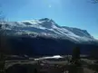 Beiarn landscape with snowy mountains, a valley, and a small lake under a clear blue sky