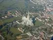 Aerial view of Salisbury Cathedral School, a gothic cathedral, and the surrounding town landscape with a river.