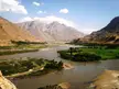 Panj river winding through a green valley and arid mountains on the Tajikistan and Afghanistan border