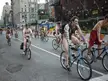 Group of naked men with body paint riding bicycles on a city street during a naked bike ride.