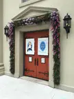 Cathedral Basilica of St. Augustine orange double doors with floral garlands and black lanterns on a beige wall