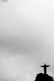 Christ the Redeemer statue in Rio de Janeiro silhouetted against a cloudy sky in black and white landscape photography