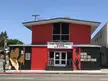 Shotgun Players theater in Berkeley, California, featuring red and black walls with murals and signage.