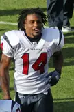 Townsel in a white Houston Texans jersey with number 14, showing tattoos on his right arm on a grass field.