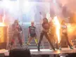 The Pussycat Dolls in black crop tops, booty shorts, and leggings performing on a stage with pyrotechnics.