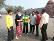 Haley and a group of friends in casual wear, including a floral print skirt, standing before a red sandstone fortress.