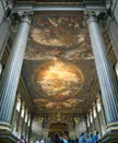 Trompe-l'œil ceiling painting in an ornate hall with fluted columns and a group of people in casual clothing