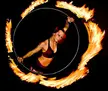 A red-haired woman in maroon clothing performing with a flaming hula hoop in New York City