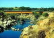Knights Ferry Covered Bridge spanning the rocky Stanislaus River in a California landscape
