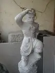 A Chinese anthropomorphic stone statue of a monkey in traditional costume standing on a cloud base.