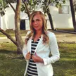 Ekaterina Renzhina, a slender blonde woman with pale skin wearing a white blazer and striped top outdoors.