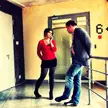 A man in a grey blazer and blue jeans talking to a woman in a red long-sleeved shirt and black skirt at #yandex