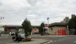 Weymouth railway station street scene with people, a dog, and BMW cars under a cloudy sky