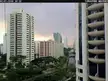 Singapore city skyline with high-rise apartment buildings and a canal under a cloudy sky