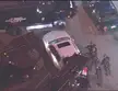 White car between two tow trucks with LAPD officers in dark uniforms in a night parking area